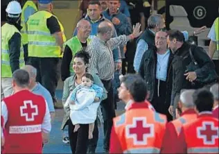  ?? JAIME REINA / AFP ?? Una madre desembarca con su hijo en brazos en el puerto de Palma