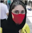  ??  ?? Reyhane Rajaei wears a mask at a gold market of Tehran’s Grand Bazaar.