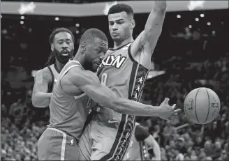  ?? MARY SCHWALM/AP PHOTO ?? Boston Celtics guard Kemba Walker passes around Brooklyn Nets guard Timothe Luwawu-Cabarrot, right, during the second half of Tuesday’s game in Boston.