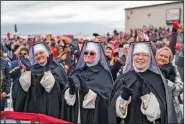  ?? (The New York Times/Doug Mills) ?? Nuns turn out Friday for President Donald Trump’s rally in Waterford Township, Mich. At right, a group of women listens to Vice President Joe Biden at his drive-in campaign event at the Iowa State Fairground­s.