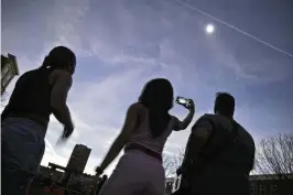  ?? ?? The crowd at National Road Commons Park is shrouded in darkness during the total eclipse. Viewers at the park enjoyed live music and food trucks while awaiting the oncein-a-lifetime event.