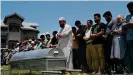  ??  ?? Relatives and neighbors offer prayers at the funeral of Bashir Ahmed Khan