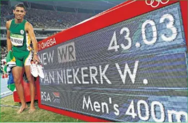  ??  ?? ORGULLOSO. Wayde Van Niekerk posa junto al marcador que registró su récord del mundo de 400 metros.