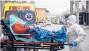  ?? OMAR MARQUES/AP ?? Paramedics rush a COVID-19 patient into a hospital Sunday in Bochnia, Poland. More than 55,000 people have died of the virus in Poland.