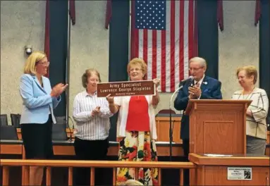  ?? CHAD FELTON — THE NEWS-HERALD ?? Marsha Stapleton holds a model of the highway sign designated on a portion of Interstate 90 honoring her late brother on Sept. 12 at Euclid City Hall. State Senate Minority Leader Kenny Yuko, right, and Euclid Mayor Kirsten Holzheimer Gail, far left,...