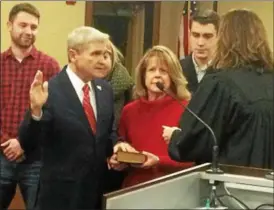  ?? KRISTI GARABRANDT — THE NEWS-HERALD ?? Willoughby Mayor Robert Fiala is surrounded by his family as Willoughby Municipal Court judge Marisa Cornachio administer­s the oath of office during the Jan. 2 City Council meeting at Willoughby City Hall.
