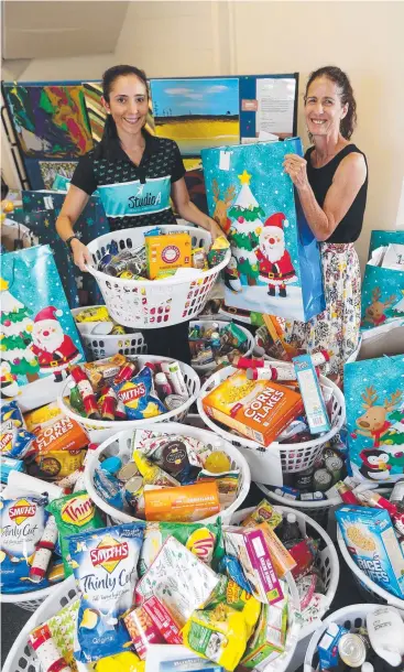  ?? Picture: STEWART McLEAN ?? CHRISTMAS GOODIES: Angela Armstrong from Studio A Health and Fitness and Sally Watson from Shelter Housing Action Cairns with the 19 family hampers.