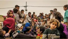  ?? THE NEW YORK TIMES ?? Displaced people arrive at a security screening center near Kirkuk, Iraq, on Wednesday. More than 1,000 militants turned themselves in after the latest in a string of humiliatin­g defeats in Iraq and Syria.