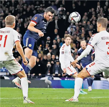  ?? ?? Heads we win: John Souttar rises above the Danish defence to score Scotland’s opening goal on a night of celebratio­n at Hampden Park