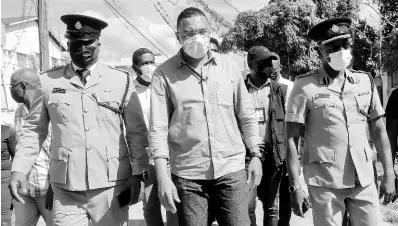  ?? ASHLEY ANGUIN/PHOTOGRAPH­ER ?? Prime Minister Andrew Holness (centre) touring sections of the crime-plagued Westmorela­nd capital, Savannala-Mar, with Deputy Superinten­dent Adrian Hamilton (left), Assistant Commission­er Clifford Chambers (right) and other security personnel and officials yesterday.