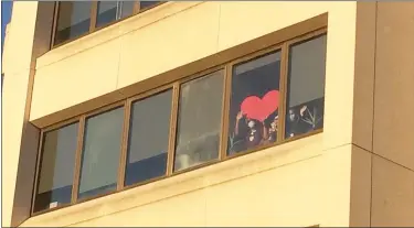  ?? EVAN BRANDT — MEDIANEWS GROUP ?? Workers on the floor dealing with COVID-19cases held up a giant heart to show their appreciati­on for Wednesday’s parade.