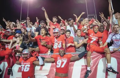  ?? ROBERTO E. ROSALES/JOURNAL ?? UNM football players celebrate with the crowd after the Lobos defeated rival New Mexico State last season at University Stadium. The rivalry game drew more than 28,000 fans, but other UNM home games had sparse crowds last season.