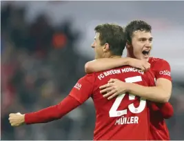  ?? — AP ?? Bayern's Thomas Mueller (front) and Benjamin Pavard celebrate at the end of the German Bundesliga match against Borussia Dortmund in Munich on Saturday.