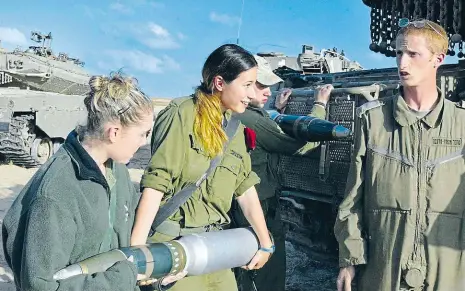  ?? Foto: Reuters ?? Trable s municí Izraelky na archivním snímku pomáhají přenášet munici. Právě ta se ukázala jako jeden z řady důvodů, proč ženy nejspíš nebudou moci do tanků. Granáty jsou příliš těžké, aby je žena sama dokázala unést.