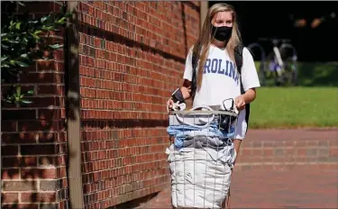  ?? Related article, 1B ?? Sarah Anne Cook, a freshman at the University of North Carolina at Chapel Hill, moves out of her dormitory Tuesday as a cluster of coronaviru­s cases was reported on campus. The university announced that it would cancel in-person undergradu­ate sessions starting today. (AP/Gerry Broome)
