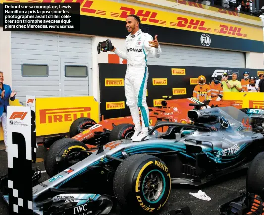  ?? PHOTO REUTERS ?? Debout sur sa monoplace, Lewis Hamilton a pris la pose pour les photograph­es avant d’aller célébrer son triomphe avec ses équipiers chez Mercedes.