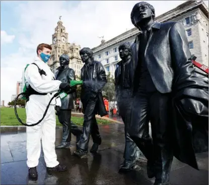  ?? CARL RECINE / REUTERS ?? Statues of Liverpool’s most famous musical exports, The Beatles, get sprayed down in the northern English city on Oct 1.