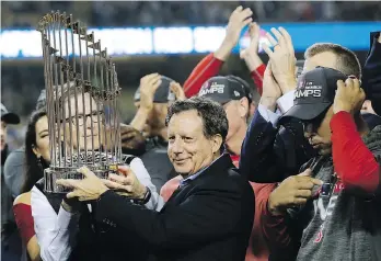  ?? DAVID J. PHILLIP/THE ASSOCIATED PRESS ?? Red Sox owner John Henry, partly hidden behind the Commission­er’s Trophy, and club chairman Thomas Werner are on top of the world after winning the World Series last Sunday.