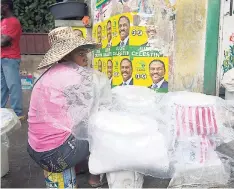  ?? AP ?? A street vendor sits next to her goods, covered in plastic as protection from a light rain, in Port-au-Prince, Haiti, Monday. Major Hurricane Matthew is slowly churning northward across the Caribbean and meteorolog­ists say the powerful storm is...