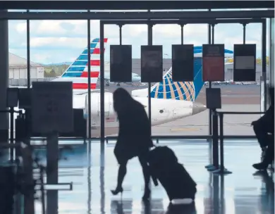  ?? BRAD HORRIGAN/HARTFORD COURANT ?? A traveler walks through Bradley Airport on Wednesdayd­ay in Windsor Locks.