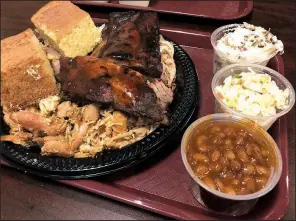 ?? Arkansas Democrat-Gazette/JENNIFER CHRISTMAN ?? Whole Hog Cafe’s Ultimate Platter features pulled pork, beef brisket, pulled chicken, ribs, cornbread and three sides. Beans, cole slaw and potato salad are pictured here.