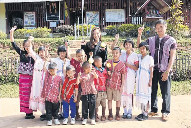  ??  ?? Students and teachers in traditiona­l highland costumes in front of Ban Pang Tong School in Mae Hong Son.