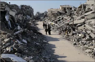  ?? (File Photo/AP/Mahmoud Essa) ?? Palestinia­ns walk
Thursday through the destructio­n from the Israeli offensive in Jabaliya refugee camp in the Gaza Strip.