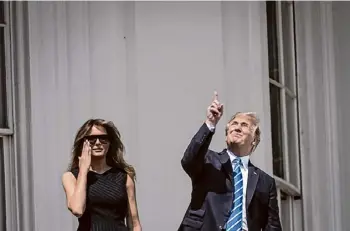  ?? Jabin Botsford/Washington Post News Service ?? President Donald Trump looks up toward the Aug. 21, 2017, solar eclipse without glasses, with first lady Melania Trump by his side. Experts warn not to do this Monday, saying the first rule of eclipse viewing is to avoid looking directly at the sun without eye protection. Even brief glances can cause permanent damage.