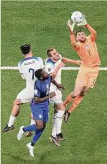  ?? Hassan Ammar/ Associated Press ?? American goalkeeper Matt Turner leaps to grab the ball next to England's Harry Kane (second from right) during the World Cup Group B match in Al Khor, Qatar, on Friday.