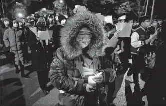  ?? Ng Han Guan/associated Press ?? Protesters angered by strict anti-virus measures march in Beijing on Sunday, calling for China’s powerful leader to resign — a rare direct challenge to the ruling Communist Party.