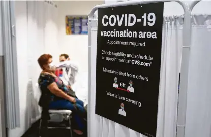  ?? Marcio Jose Sanchez / Associated Press ?? A patient receives a shot of the Moderna vaccine Monday next to a guidelines sign at a CVS Pharmacy in Los Angeles. More than 27 million Americans fully vaccinated against the virus will have to keep waiting for guidance from U.S. health officials.