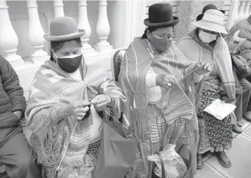  ?? JUAN KARITA/AP ?? Knitting before vaccine needles: While waiting Wednesday for the AstraZenec­a COVID-19 vaccine, women knit at a state social security clinic in La Paz, Bolivia. The country has logged more than 284,000 confirmed infections.