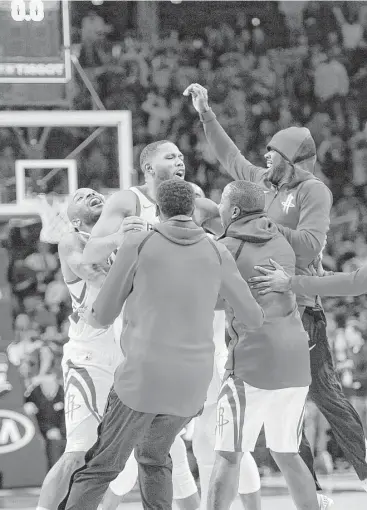  ?? Michael Perez / Associated Press ?? Eric Gordon, center, draws a crowd after sinking the game-winner for the Rockets from 3-point range.