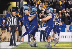  ?? PATRICK SEMANSKY/THE ASSOCIATED PRESS ?? Navy quarterbac­k Keenan Reynolds (19) celebrates with teammates after his third rushing touchdown Monday against Pitt in the Military Bowl.