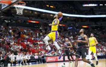  ?? BRYNN ANDERSON — THE ASSOCIATED PRESS ?? Lakers forward LeBron James scores during the first quarter of a game against the Heat Sunday in Miami, Fla.