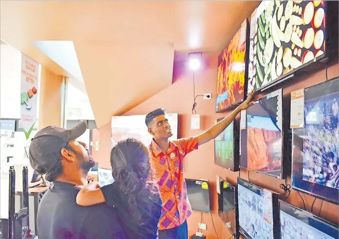 ?? Picture: JOVESA NAISUA ?? Courts employee Shahil Chand and customer Nitish Ram check out the features of the Toshiba 50” Android Smart 4k UHD TV at the Courts Nakasi branch.