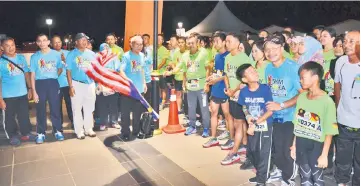  ??  ?? Talib flagging-off the runners at the starting line.