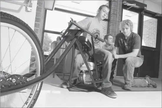  ?? Photos, Lorraine Hjalte, Calgary Herald ?? Grade 10 student Tyler Down, left, Jason Wilton, and Jesse Arik, who are both in Grade 12, with a bike they built at Coalhurst High School, a rural high school where students are performing well. They took first place in a motorized bike building...