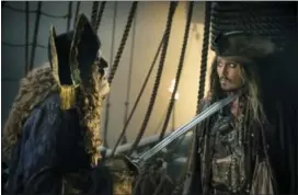  ?? PETER MOUNTAIN — DISNEY VIA AP ?? In this image released by Disney, Geoffrey Rush portrays Barbossa, left, and Johnny Depp portrays Captain Jack Sparrow in a scene from “Pirates of the Caribbean: Dead Men Tell No Tales.”