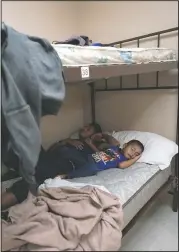  ?? (AP/Julio Cortez) ?? A 4-year-old migrant boy sleeps next to his father at a shelter in Harlingen, Texas. The father and son were taken into the shelter for the night while they wait for their flight the next morning after they were released from U.S. Customs and Border Protection custody.