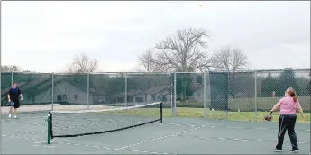  ?? Keith Bryant/The Weekly Vista ?? Andy Fosdick (left, background) waits as the ball sails his way after Jessie Fosdick returns the volley at the Metfield pickleball court.