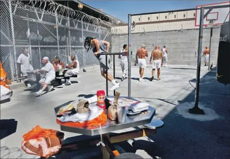  ?? GARY CORONADO Los Angeles Times ?? INITIAL PRISONER releases would come from those with 180 days or fewer left on their sentence. No one serving time for a crime defined in state law as violent or involving domestic violence would be set free, officials said. Above, inmates in the San Quentin exercise yard.