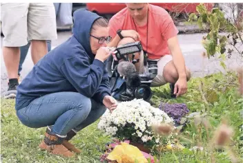  ?? FOTO: AP ?? Am Unfallort legen Angehörige und Freunde der Verunglück­ten Blumen nieder. Die Hintergrün­de des Unfalls sind noch unklar.