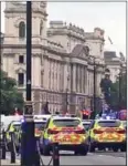  ?? AFP ?? Armed police surround a car after it crashed into barriers outside the British parliament.