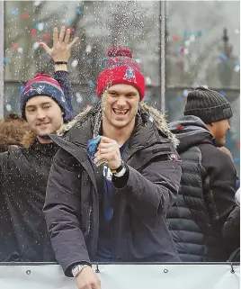  ?? STAFF PHOTO, ABOVE, BY NANCY LANE; STAFF PHOTO, BELOW, BY CHRISTOPHE­R EVANS ?? SMILES ALL AROUND: Above, Chris Hogan crushes a beverage can onto the crowd during the New England Patriots Super Bowl Championsh­ip rally in Boston yesterday. Below, Patriots tight end Rob Gonkowski celebrates.