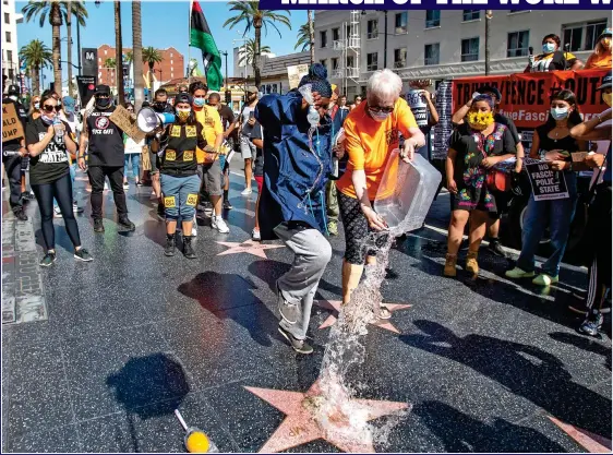  ??  ?? THE NEW INTOLERANC­E: As BLM protests rage, Refuse Fascism demonstrat­ors dump water on Donald Trump’s star on LA’s Hollywood Walk of Fame