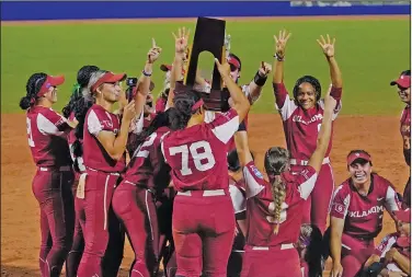  ?? Associated Press ?? Softball champions: Oklahoma players celebrate with the trophy after defeating Texas in the NCAA Women's College World 4eries softball mnals ThVrsday in Oklahoma City