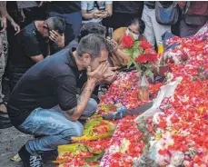  ?? FOTO: JUNI KRISWANTO/AFP ?? Nach der Tragödie im indonesisc­hen Malang trauern Angehörige der mindestens 125 Toten und legen Blumen nieder.