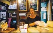  ?? JEENAH MOON — THE NEW YORK TIMES ?? Anne Saxelby of Saxelby Cheese Mongers, organizes cheese at her shop in Manhattan. Cheese prices are set, in part, by traders in commoditie­s markets.