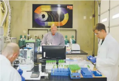  ??  ?? Peter Perrone, center, is the lab director at Gobi Analytical, the only lab in Denver that tests marijuana for pesticides. Perrone uses a liquid chromatogr­aphy-mass spectromet­ry machine Aug. 20 to test marijuana samples. Mahala Gaylord, The Denver Post